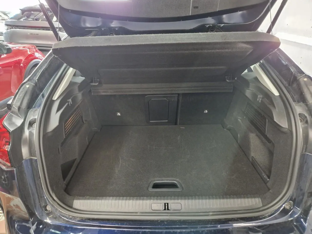 Vue intérieure côté gauche des sièges avant gris et noir avec accoudoir central et volant de la Citroën C4 2024.