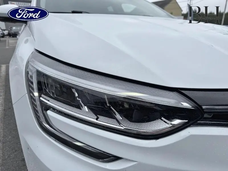 Gros plan sur le phare avant droit blanc d'une Renault Mégane 1.3 TCe 140ch Intens EDC 2022, avec détails LED visibles.