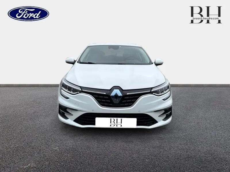 Vue avant d'une Renault Mégane blanche 2022 avec calandre noire et phares LED distinctifs.