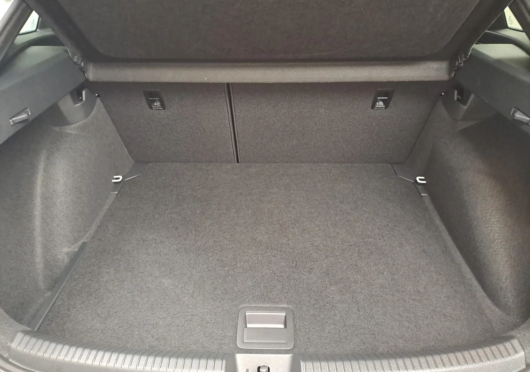 Coffre ouvert vu de face, intérieur tapissé gris foncé du Volkswagen Taigo 2025 version R-Line.