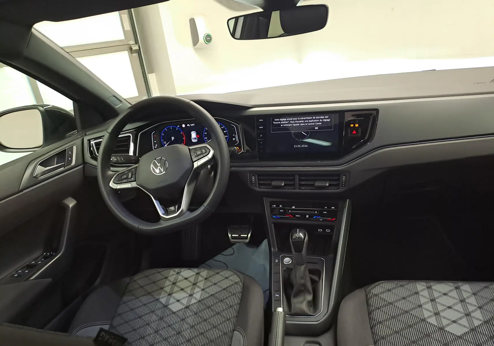 Vue intérieure avant du Volkswagen Taigo 2025, tableau de bord noir avec écran tactile et volant multifonctions cuir.