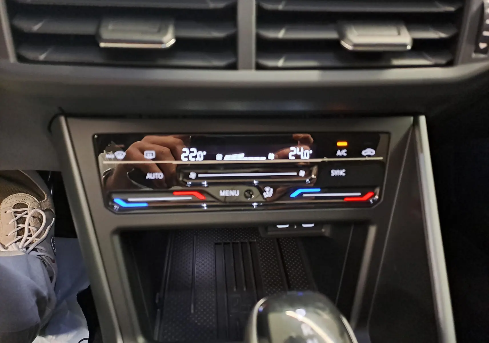 Gros plan sur la console centrale du Volkswagen Taigo 2025, affichant la climatisation bi-zone avec réglages numériques.