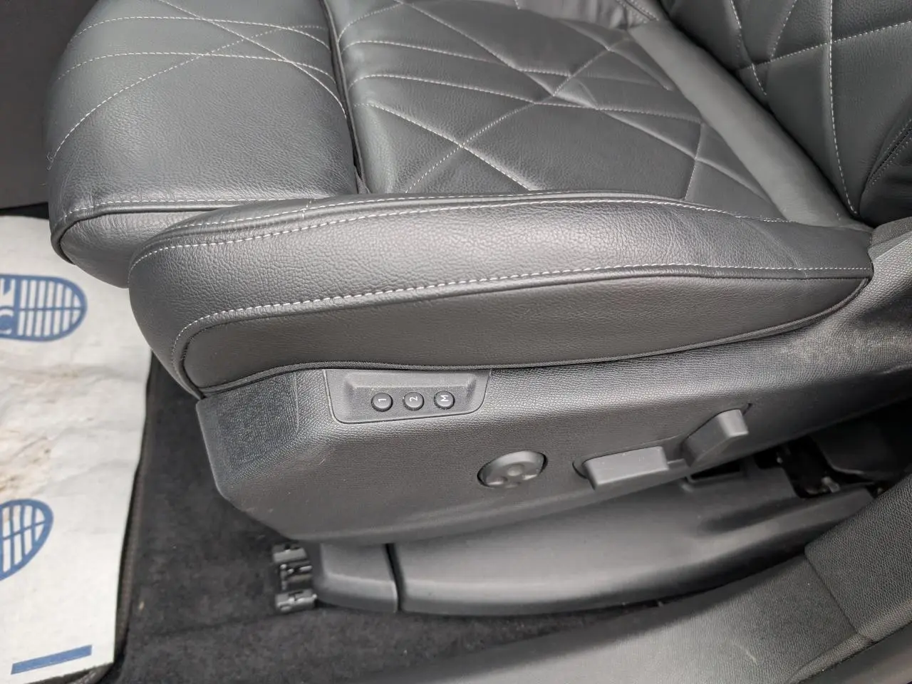 Gros plan sur le siège avant conducteur en cuir noir du DS7 2024 avec réglages électriques mémoire visibles.