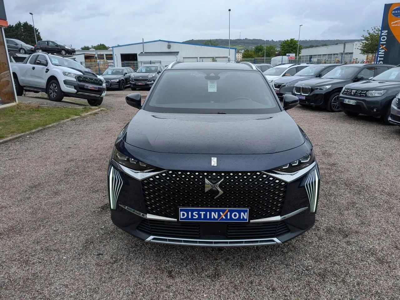 Vue avant d'un DS7 2024 bleu métallisé avec calandre DS Wings et feux LED verticaux distinctifs.