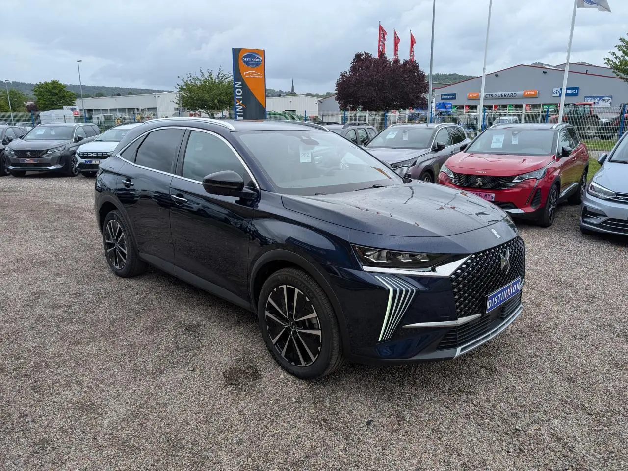 DS7 2024 bleu saphir métallisé en 3/4 avant droit avec calandre DS Wings et feux LED distinctifs.