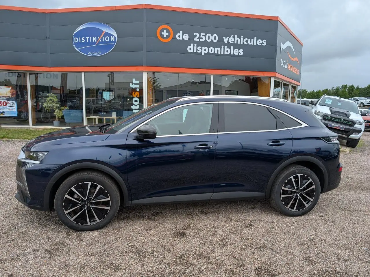 Vue latérale droite d'un DS7 2024 bleu saphir métallisé avec jantes alliage noires et vitres surteintées.