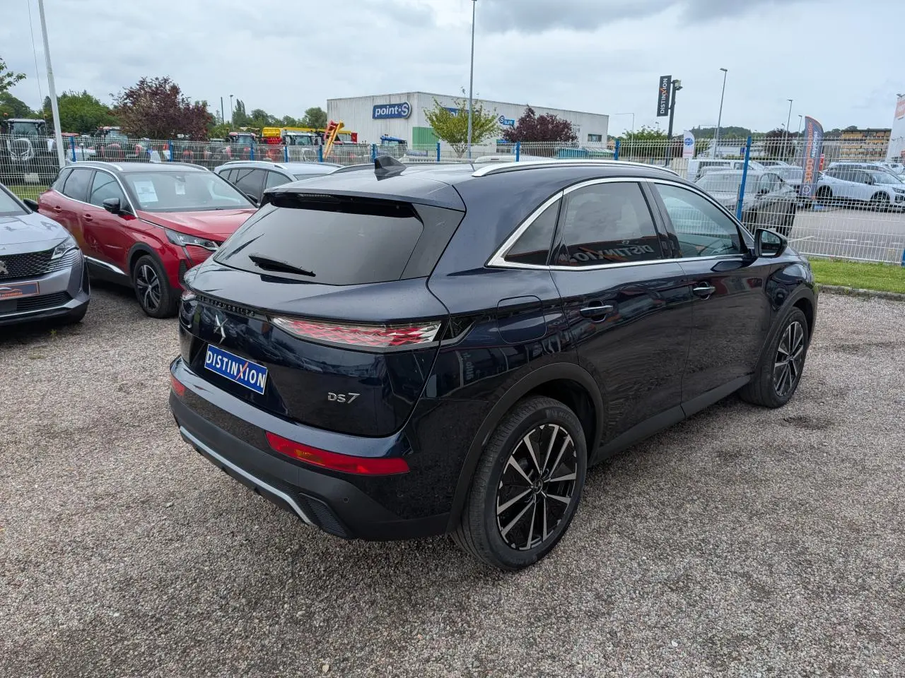 Vue 3/4 arrière droite d'un DS7 bleu métallisé avec feux arrière LED 3D et jantes alliage noires.