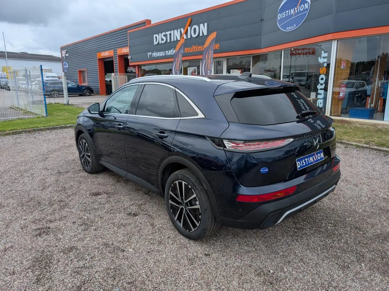 Vue 3/4 arrière droite du SUV DS7 2024 bleu métallisé avec jantes alliage noires et vitres teintées.