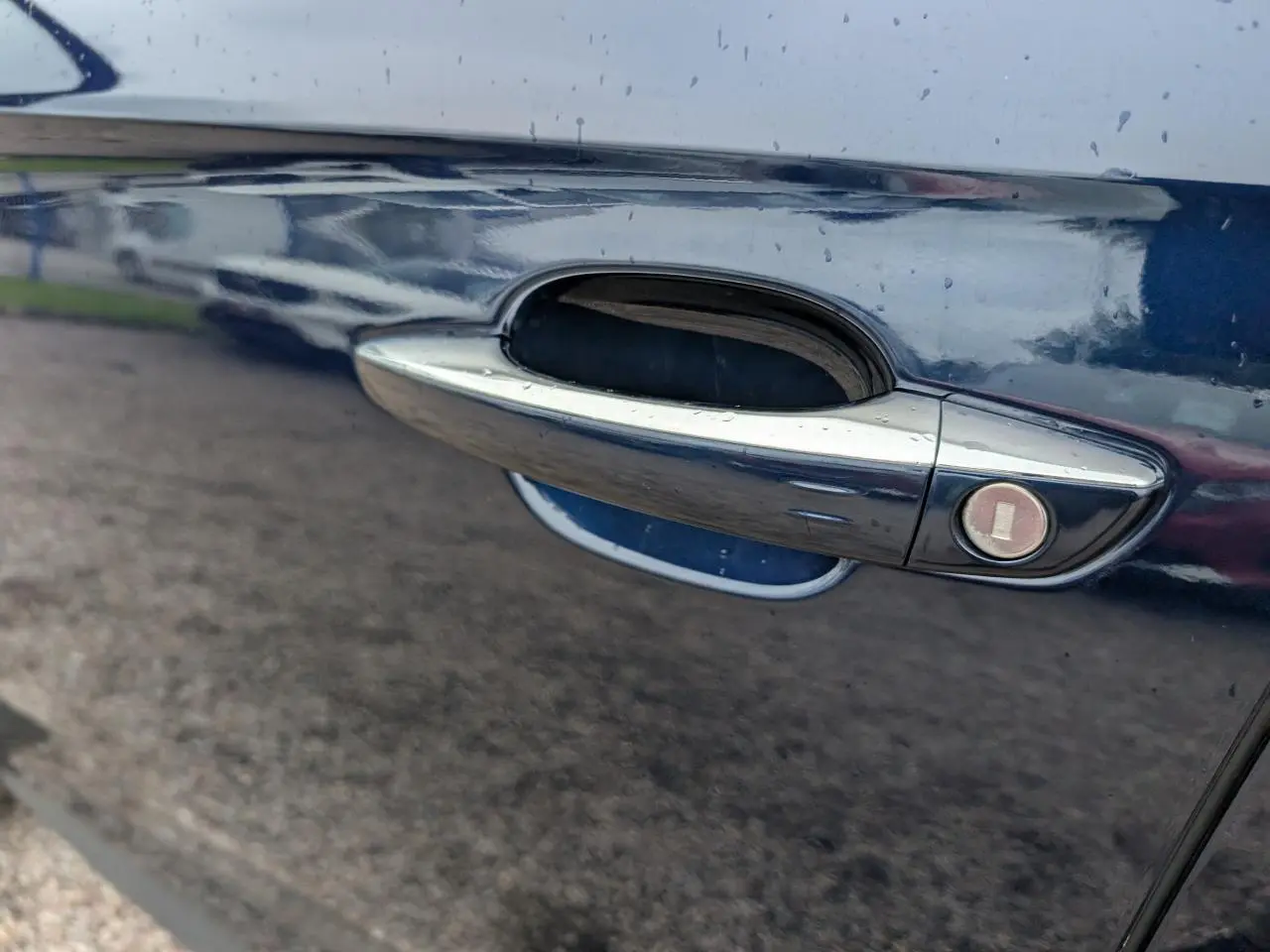 Poignée de porte chromée sur la portière côté gauche d’un DS7 bleu métallisé 2024, avec serrure intégrée.