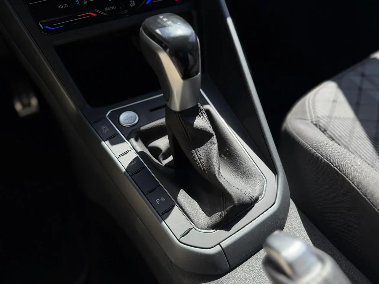 Gros plan sur la commande de la boîte automatique et le siège tissu gris du Volkswagen Taigo TSI 116 DSG R-Line 2025.