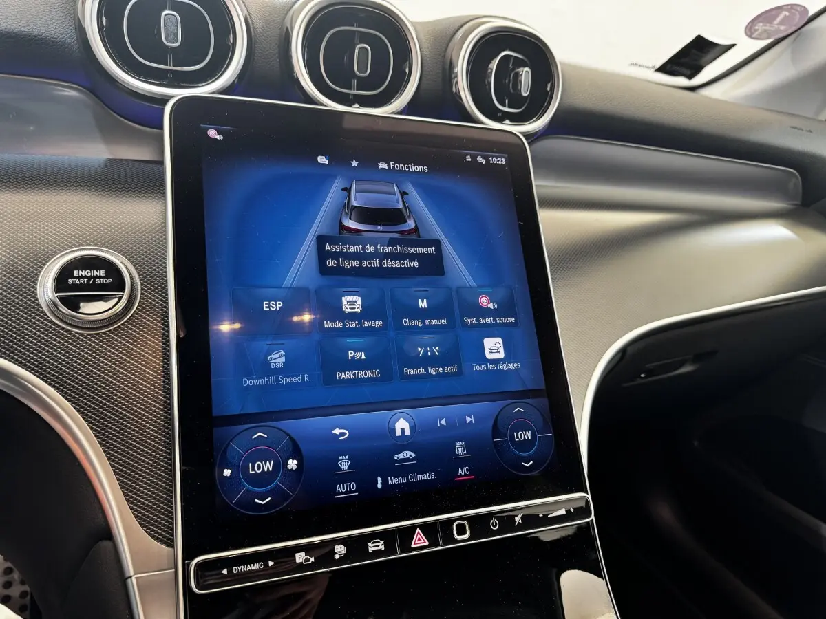 Vue intérieure du tableau de bord du Mercedes GLC 300 E Business Line 2023, écran tactile central et aérateurs ronds visibles.
