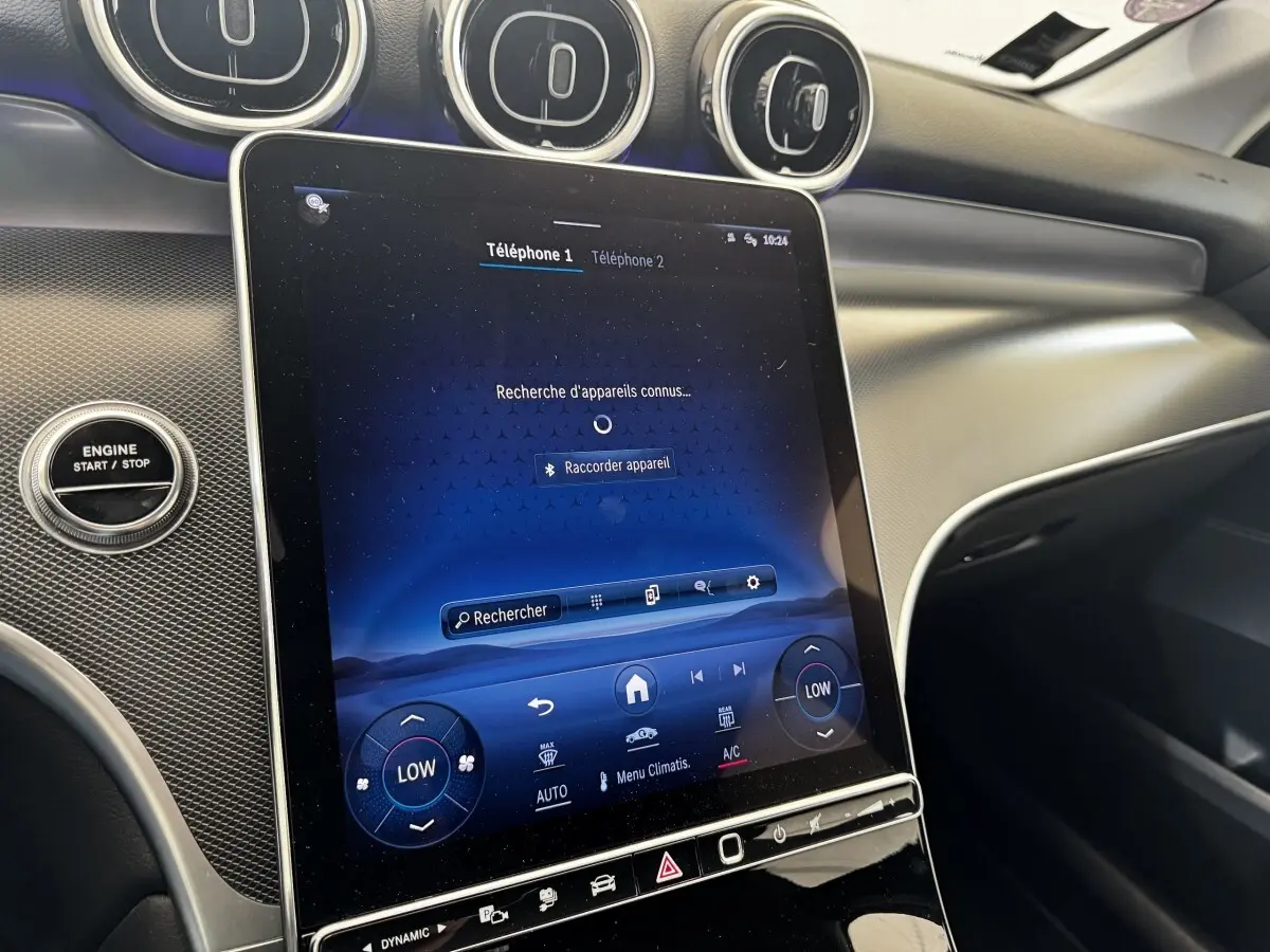 Vue intérieure du tableau de bord du Mercedes GLC 300 E Business Line 2023 avec écran tactile central et boutons de commande.