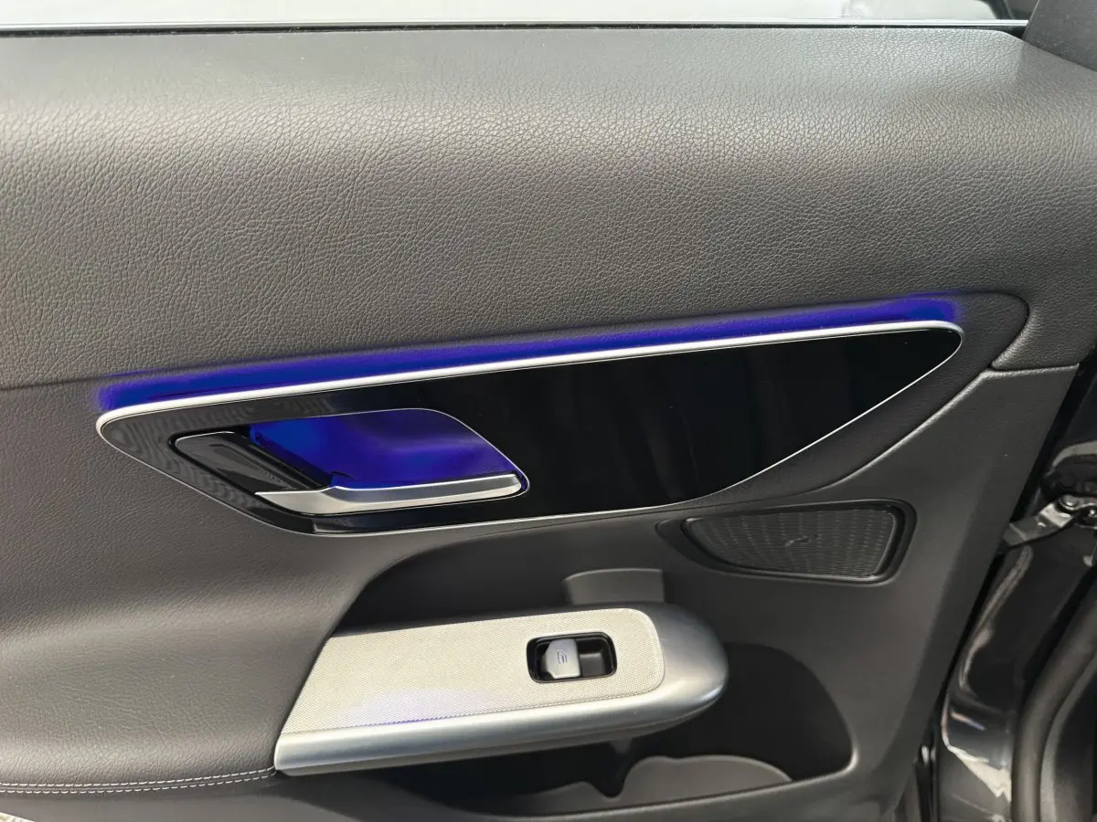 Gros plan sur la porte intérieure côté conducteur du Mercedes GLC 300 E Business Line 2023, avec éclairage d’ambiance bleu.