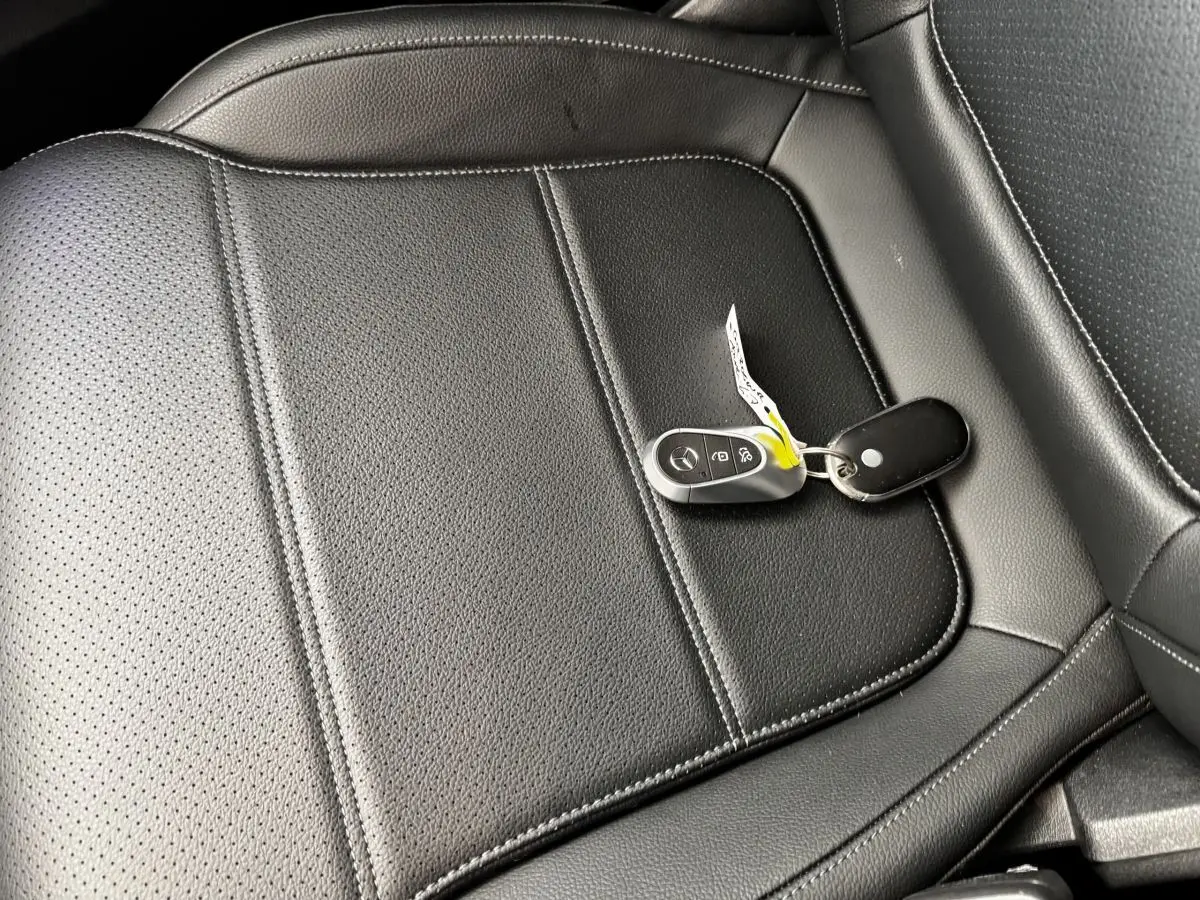 Gros plan sur la clé Mercedes posée sur un siège en cuir noir perforé de la Mercedes GLC 300 E Business Line 2023.