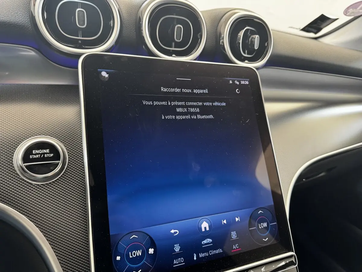 Vue rapprochée de l’écran tactile central et du bouton start/stop dans l’habitacle noir du Mercedes GLC 300 E Business Line.