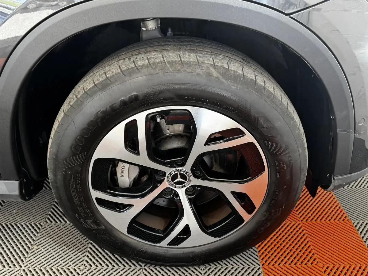 Gros plan sur la roue avant droite du Mercedes GLC 300 E Business Line gris foncé avec jante alliage bicolore.