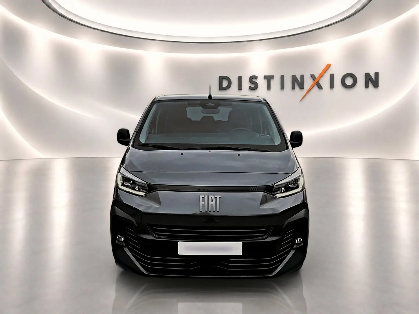 Vue frontale du FIAT Scudo Combi gris titane dans un showroom lumineux avec logo Distinxion en arrière-plan.