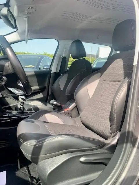 Intérieur avant droit du Peugeot 2008 gris 2015, sièges tissu et cuir, volant et levier de vitesse manuelle visibles.
