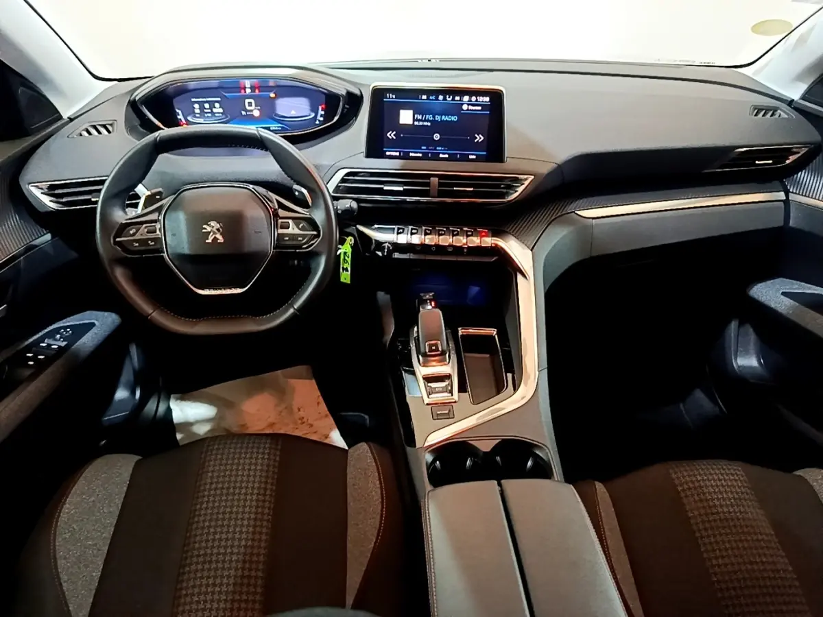 Vue intérieure avant du Peugeot 5008 2020 avec tableau de bord numérique, écran tactile central et volant cuir multifonctions.