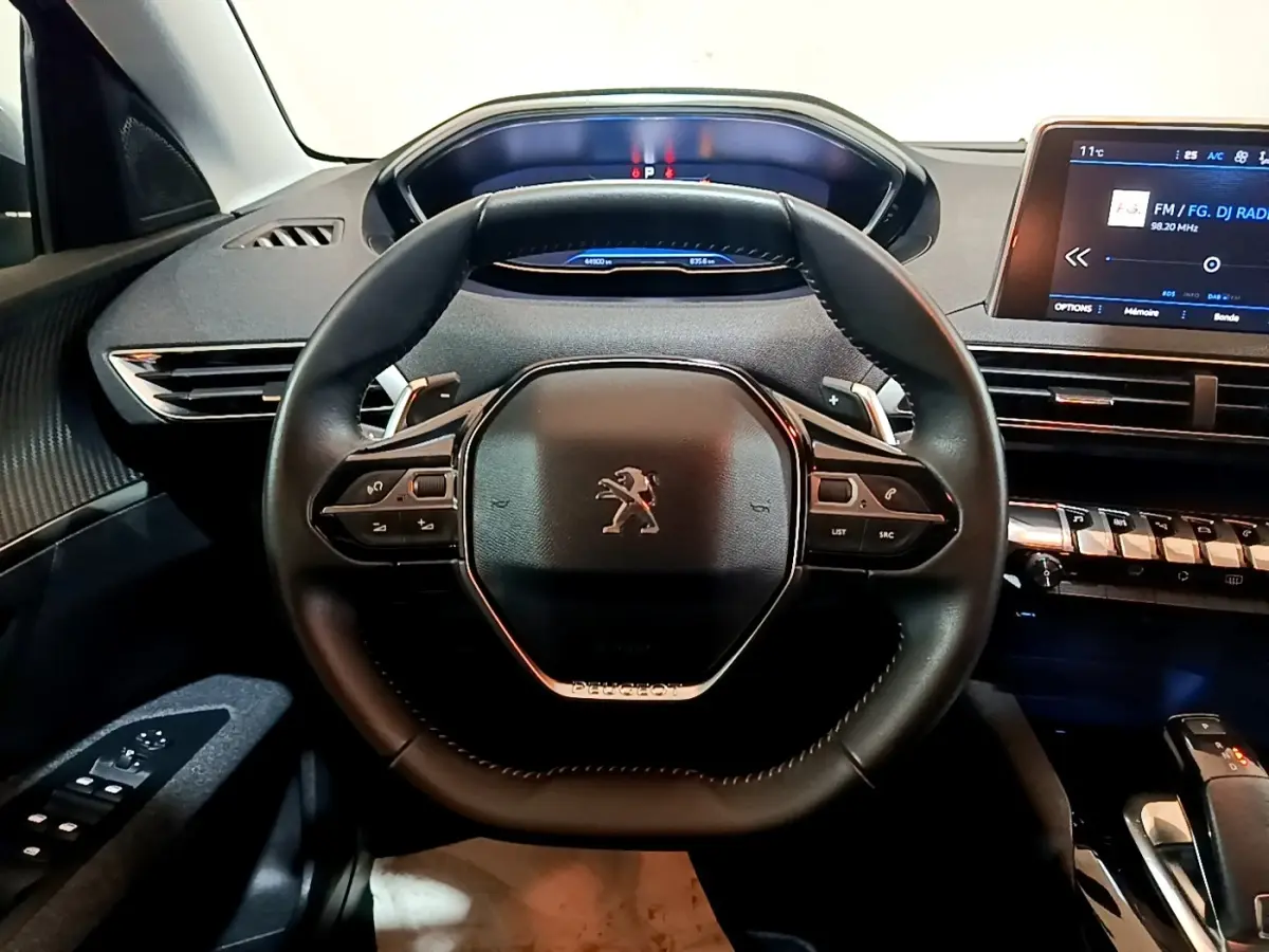 Vue rapprochée du volant cuir multifonctions et du tableau de bord numérique du Peugeot 5008 2020, intérieur noir.