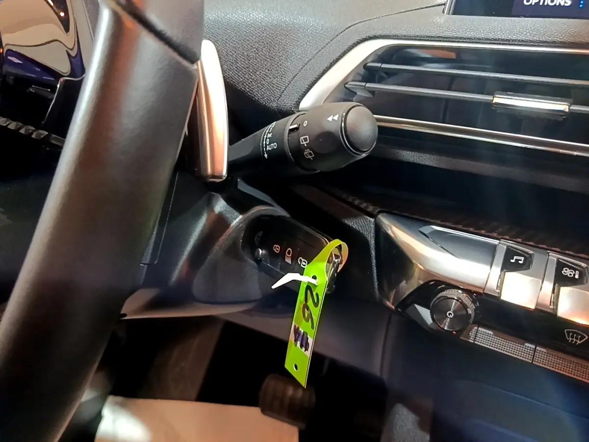 Détail intérieur du tableau de bord côté gauche du Peugeot 5008 2020, avec commande d’essuie-glace et clé insérée.