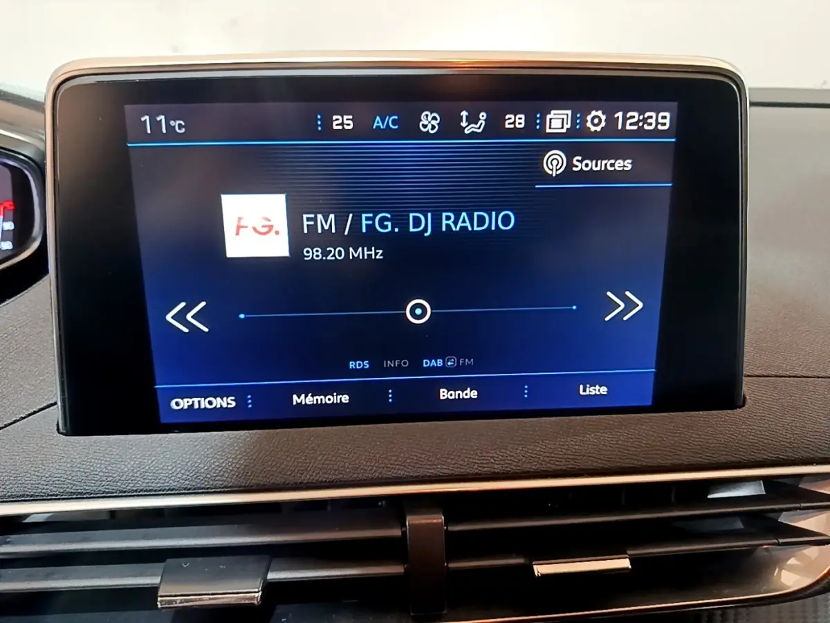 Écran tactile central du tableau de bord du Peugeot 5008 gris foncé, affichant une radio FM.