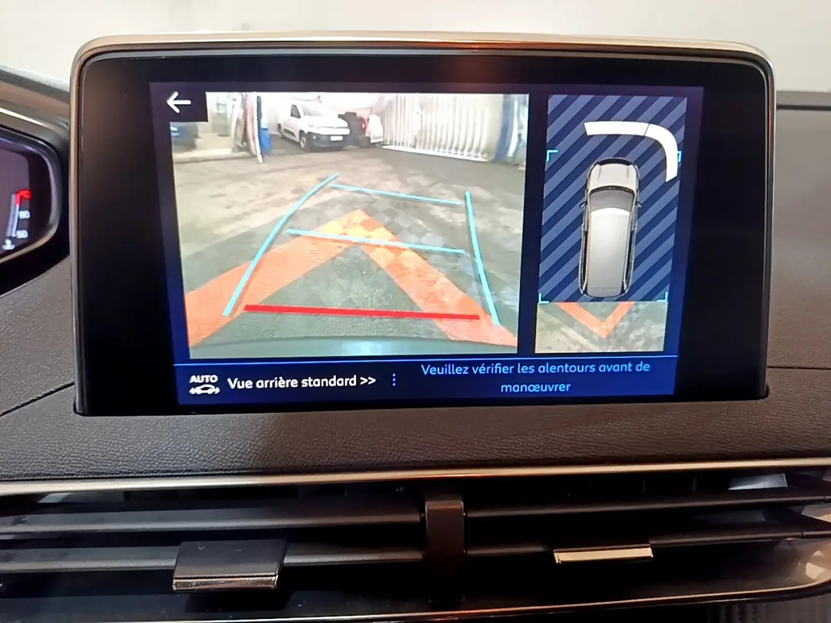 Écran tactile intérieur du Peugeot 5008 gris foncé montrant la caméra de recul et l’aide au stationnement arrière.