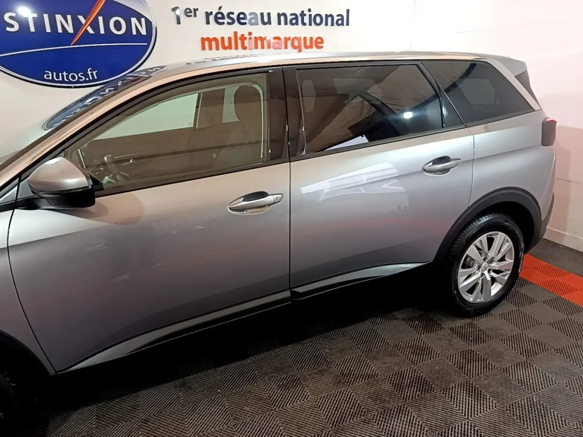 Profil côté gauche du Peugeot 5008 gris foncé 2020 dans un showroom avec rétroviseurs électriques et jantes alliage.