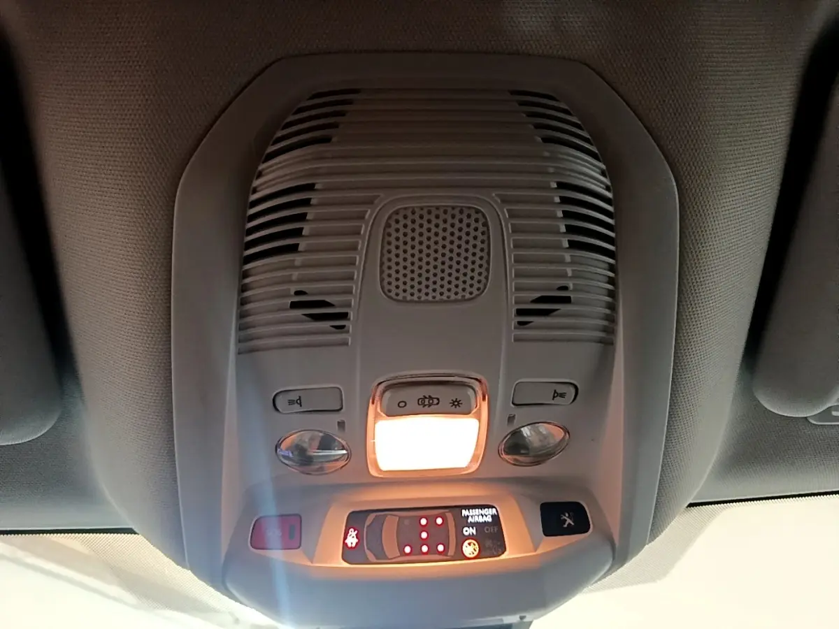 Vue intérieure du plafonnier avant du Peugeot 5008 gris foncé avec éclairage et commandes intégrées.