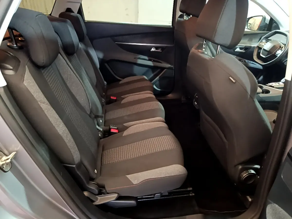 Vue intérieure côté gauche sur les sièges arrière tissu gris du Peugeot 5008 2020, avec partie avant et volant visibles.