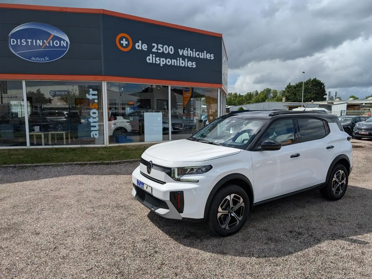 Citroën C3 Aircross blanc Banquise vue 3/4 avant droit avec toit noir Perla Nera sur parking extérieur.