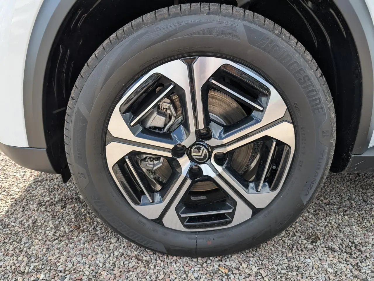 Gros plan sur la jante alliage 17'' diamantée noir et argent d'une Citroën C3 Aircross blanche, partie avant visible.
