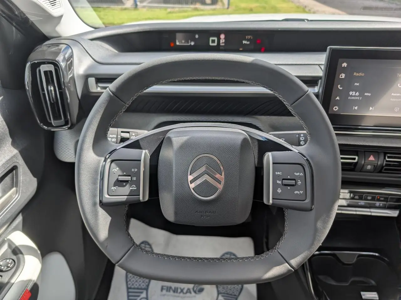 Vue intérieure centrée sur le volant multifonctions noir de la Citroën C3 Aircross 2026 avec tableau de bord et écran tactile.