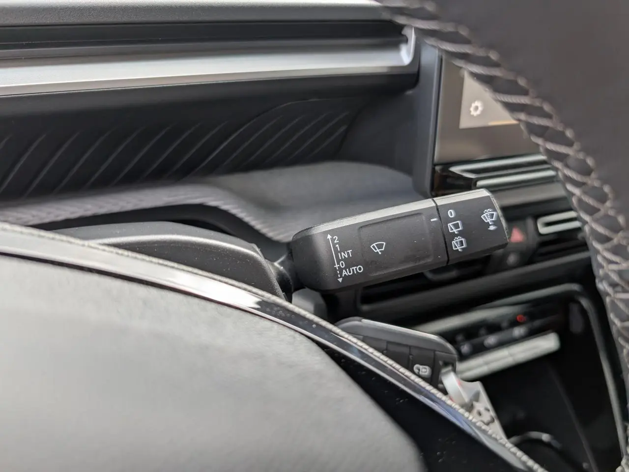 Gros plan sur la commande d’essuie-glace noire côté gauche du tableau de bord gris et noir du Citroën C3 Aircross 2026.
