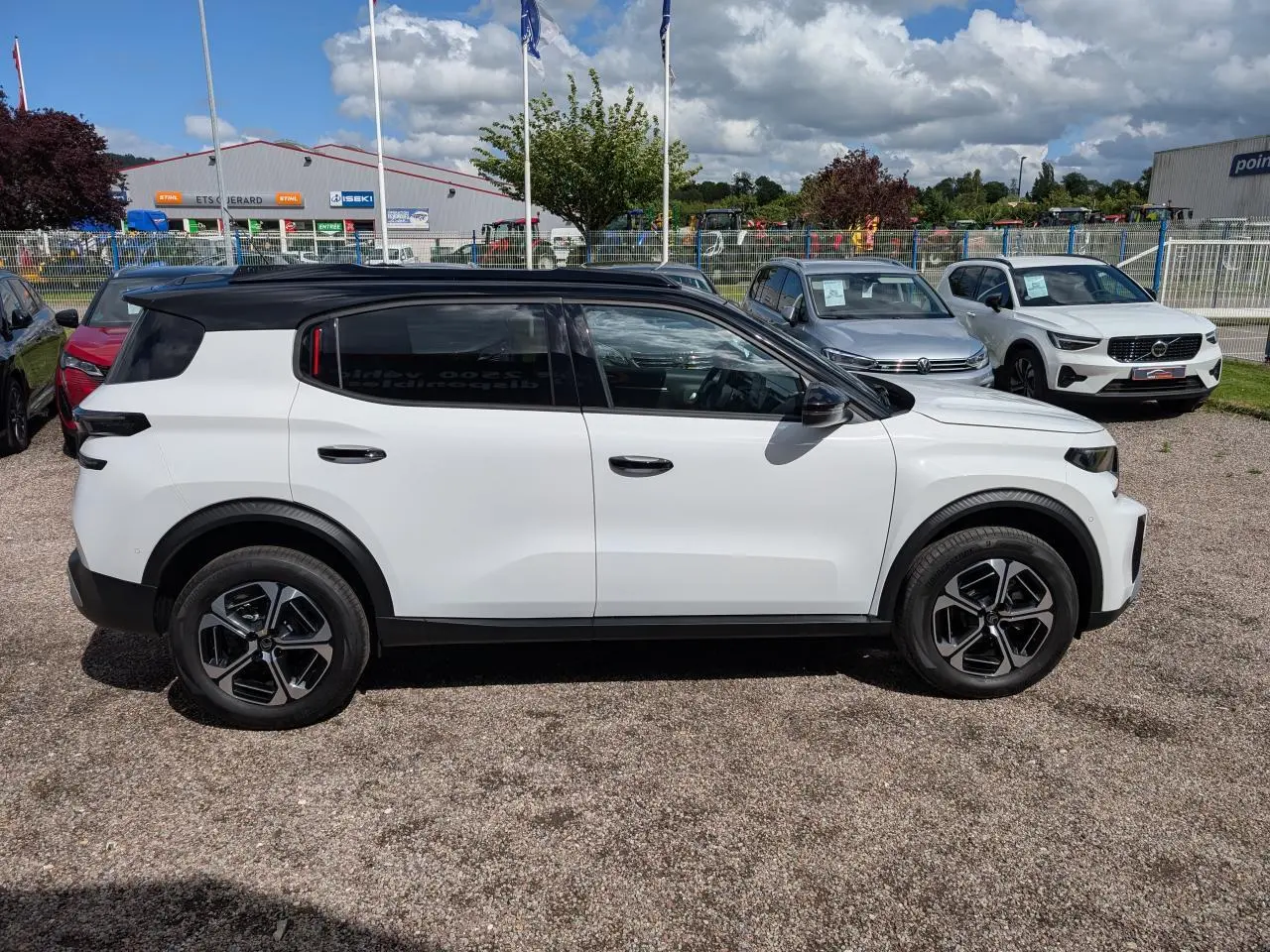 Vue de profil côté gauche d'un Citroën C3 Aircross blanc avec toit noir et jantes alliage 17 pouces.
