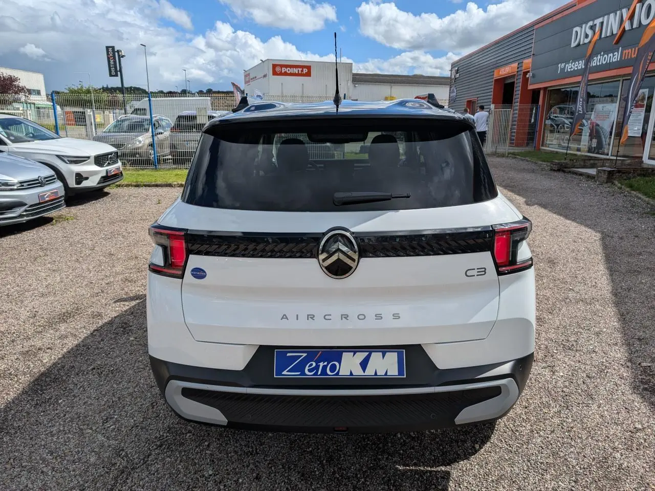 Vue arrière d'une Citroën C3 Aircross blanche avec toit noir, feux arrière LED et logo central chromé.