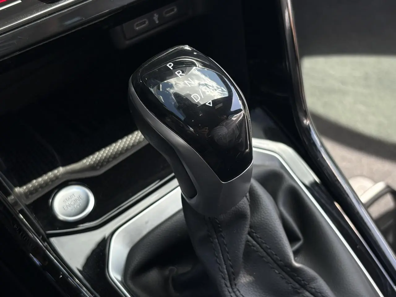 Le levier de vitesses automatique noir brillant du Volkswagen T-Roc 1.5 TSI R-Line, vue rapprochée intérieure.