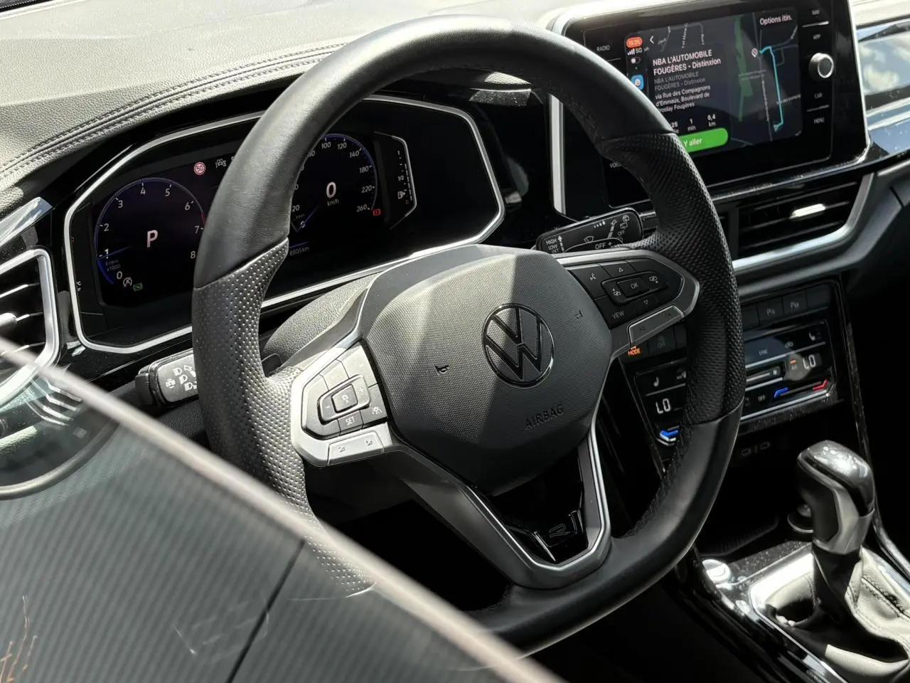 Vue rapprochée du volant cuir noir multifonction et du tableau de bord digital du Volkswagen T-Roc 2025.