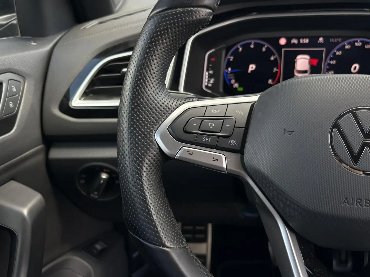 Vue rapprochée du volant cuir perforé avec commandes multifonctions et tableau de bord digital du Volkswagen T-Roc 2025.