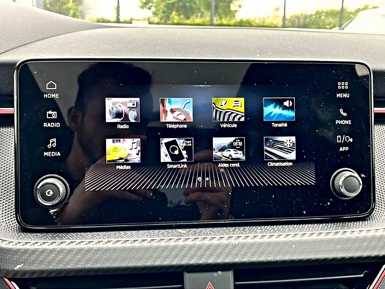 Écran tactile central du Skoda Kamiq 2026 affichant les menus radio, téléphone, véhicule et climatisation, avec cadre noir.