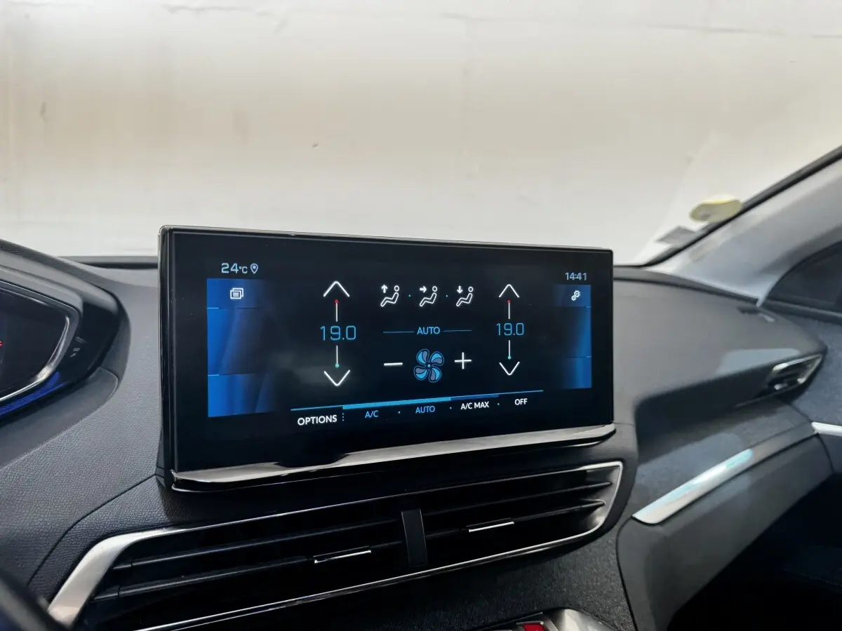 Écran tactile central affichant la climatisation à 19°C dans l'habitacle noir du Peugeot 5008, vue de face.