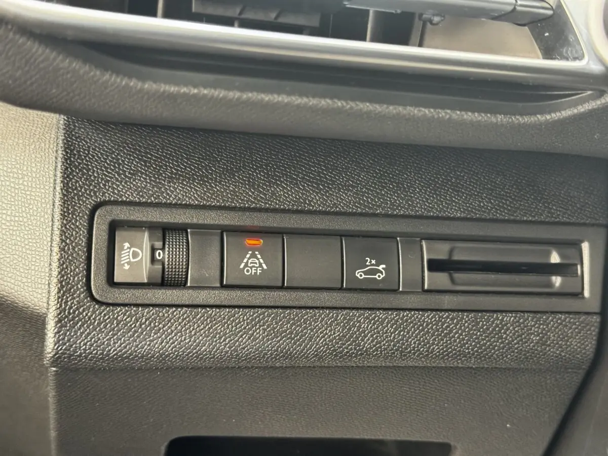 Gros plan sur les commandes noires du tableau de bord du Peugeot 5008, avec bouton d’alerte de franchissement de ligne activé.