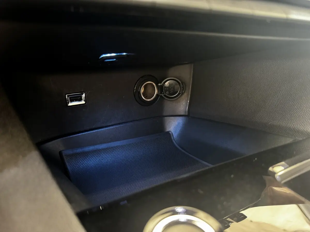 Prise USB et allume-cigare dans la console centrale noire du Peugeot 5008 BlueHDi 130 Allure Pack 2022.