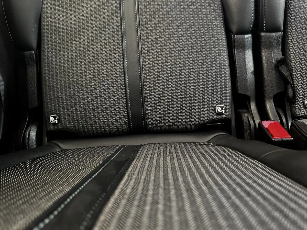 Gros plan sur la banquette arrière individuelle noire et grise du Peugeot 5008 2022 avec ceinture rouge visible.