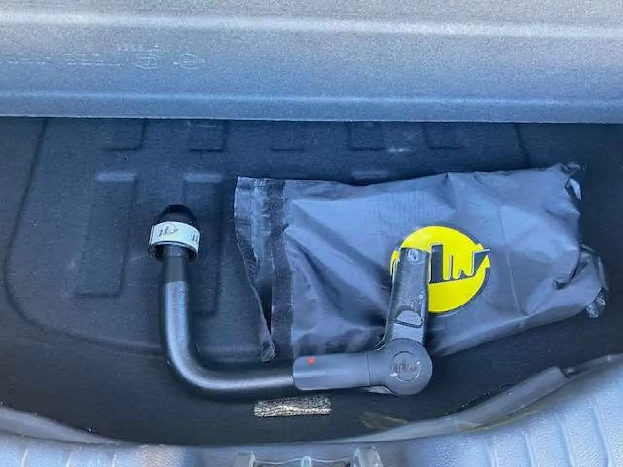 Gros plan sur l'attelage amovible noir dans le coffre du SsangYong Tivoli gris foncé 2021 version 160 e-XDi 2WD Pop.