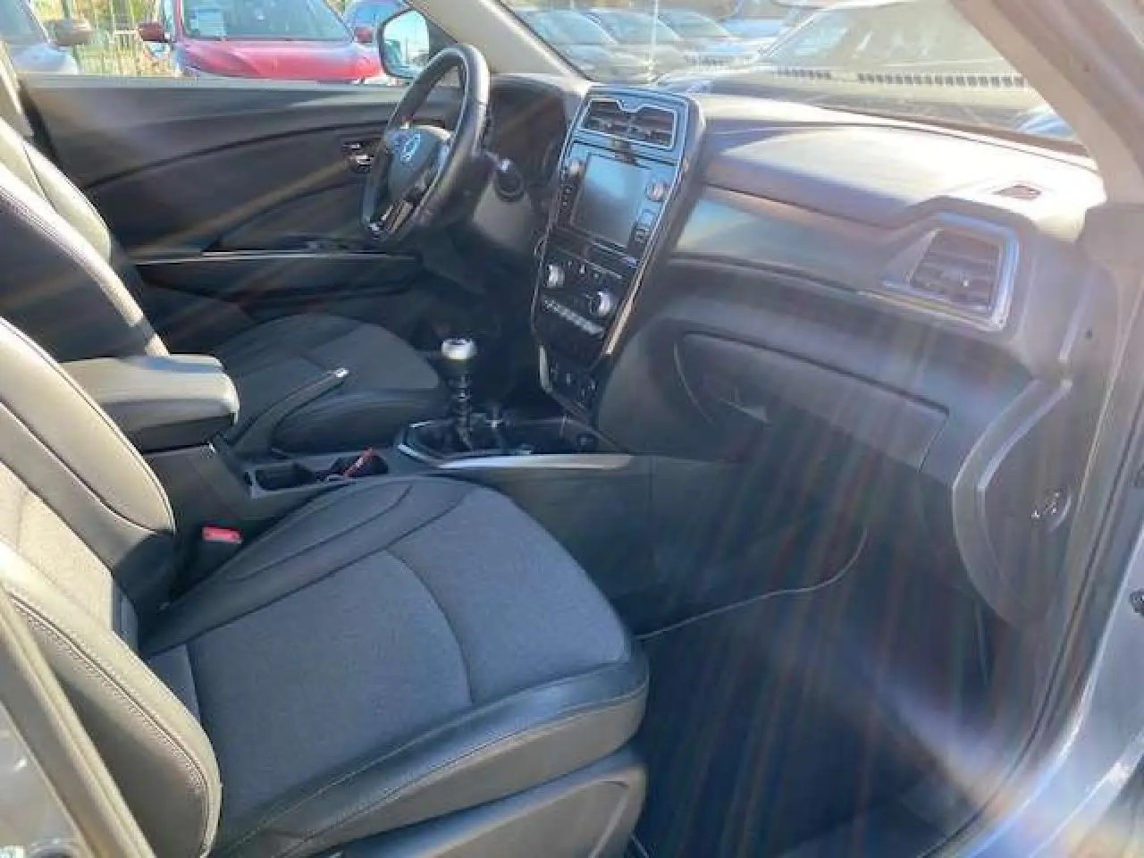 Intérieur avant droit du SsangYong Tivoli 160 e-XDi 2WD Pop 2021 gris foncé, avec tableau de bord et boîte manuelle visibles.