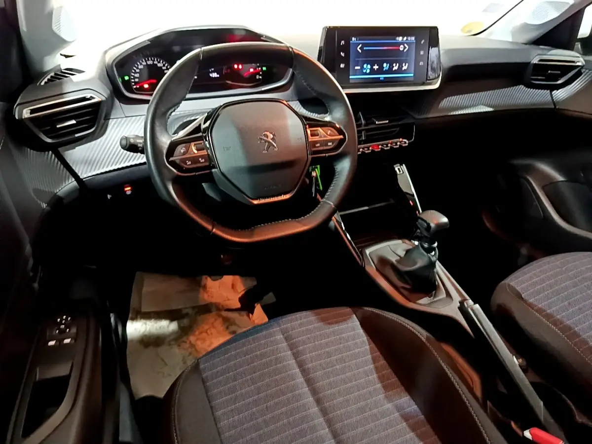 Vue intérieure avant de la Peugeot 208 1.5 BlueHDi 100 S&S Premium, volant multifonction et écran tactile central visible.