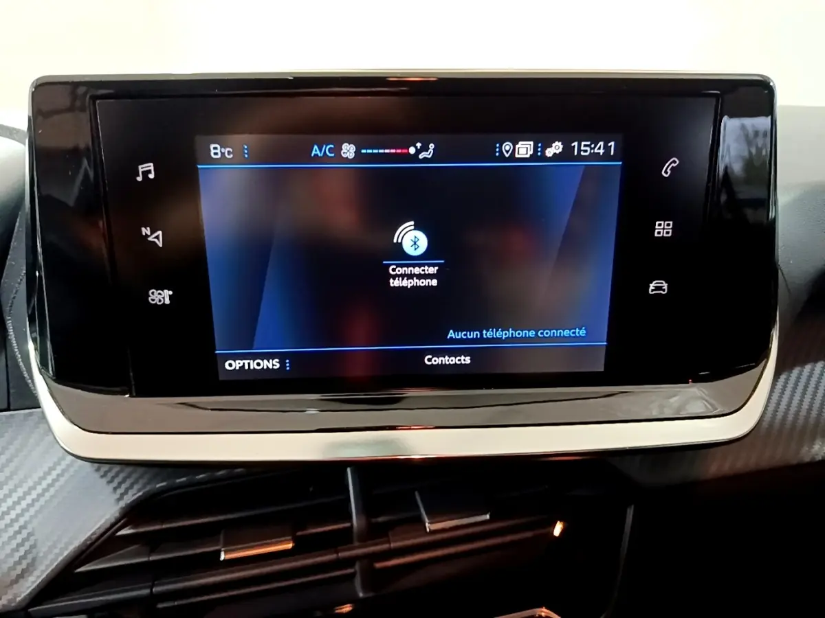 Écran tactile central de la Peugeot 208 1.5 BlueHDi 100, affichant la connexion Bluetooth au téléphone.