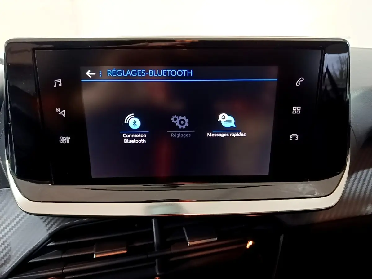 Écran tactile central de la Peugeot 208 blanc, affichant le menu réglages Bluetooth dans l’habitacle.