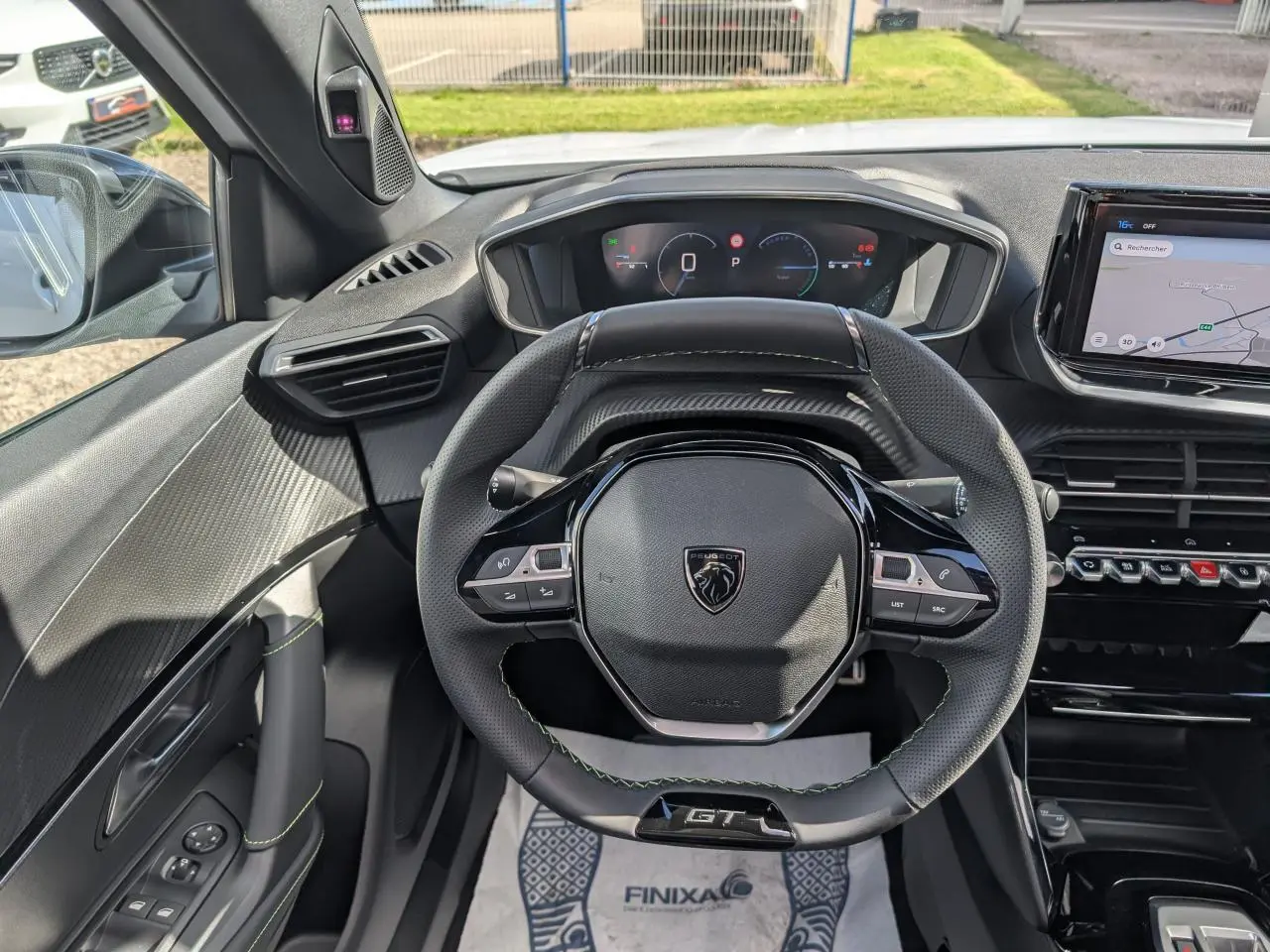 Vue intérieure centrée sur le volant GT noir avec surpiqûres vertes et tableau de bord numérique du Peugeot 2008 blanc hybride.